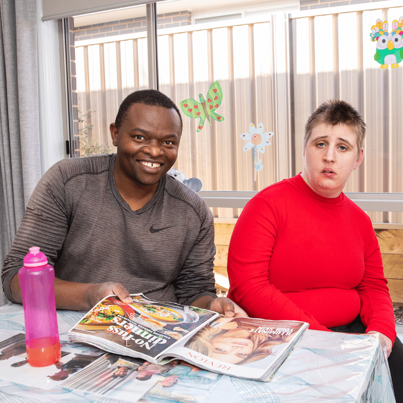 Kurrajong client and Kurrrajong staff sitting with a magazine and newspaper on the table